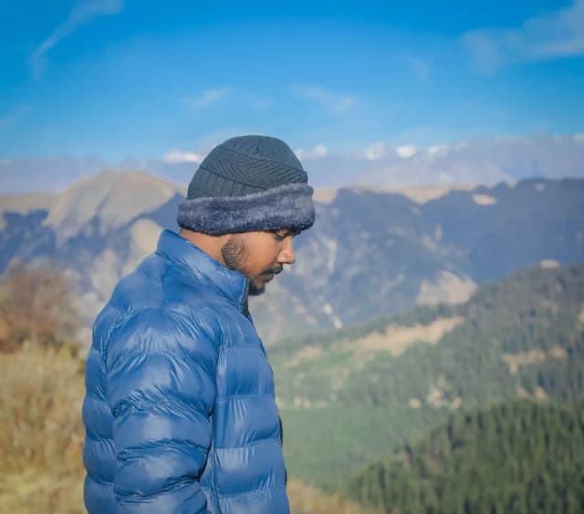 Bundled up against the cold with the mountains behind