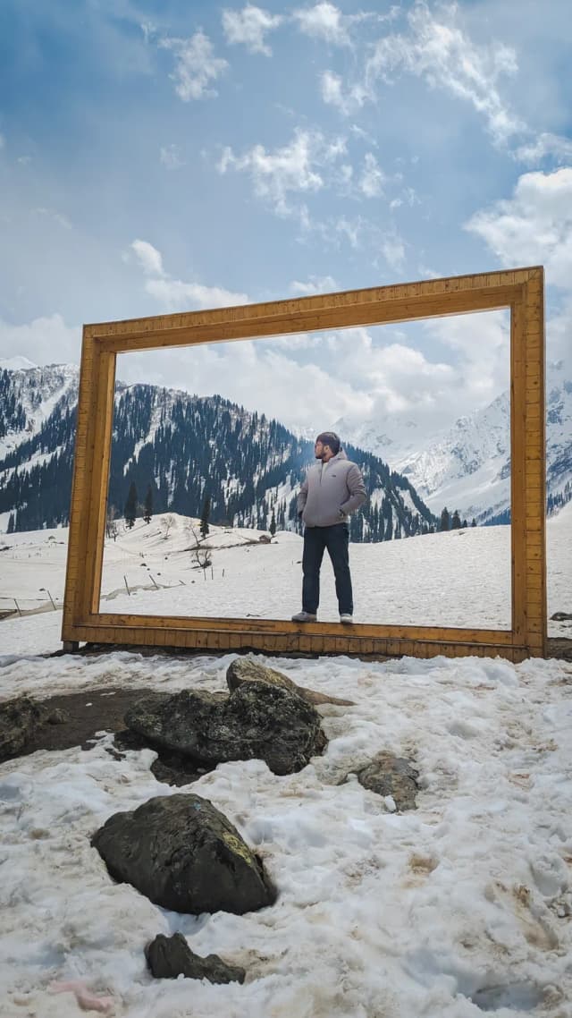 Standing inside an empty picture frame in the snow